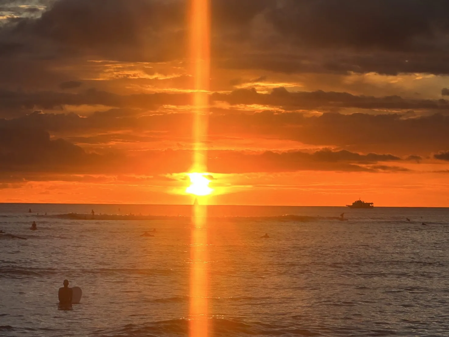海に沈む夕日とサーファー